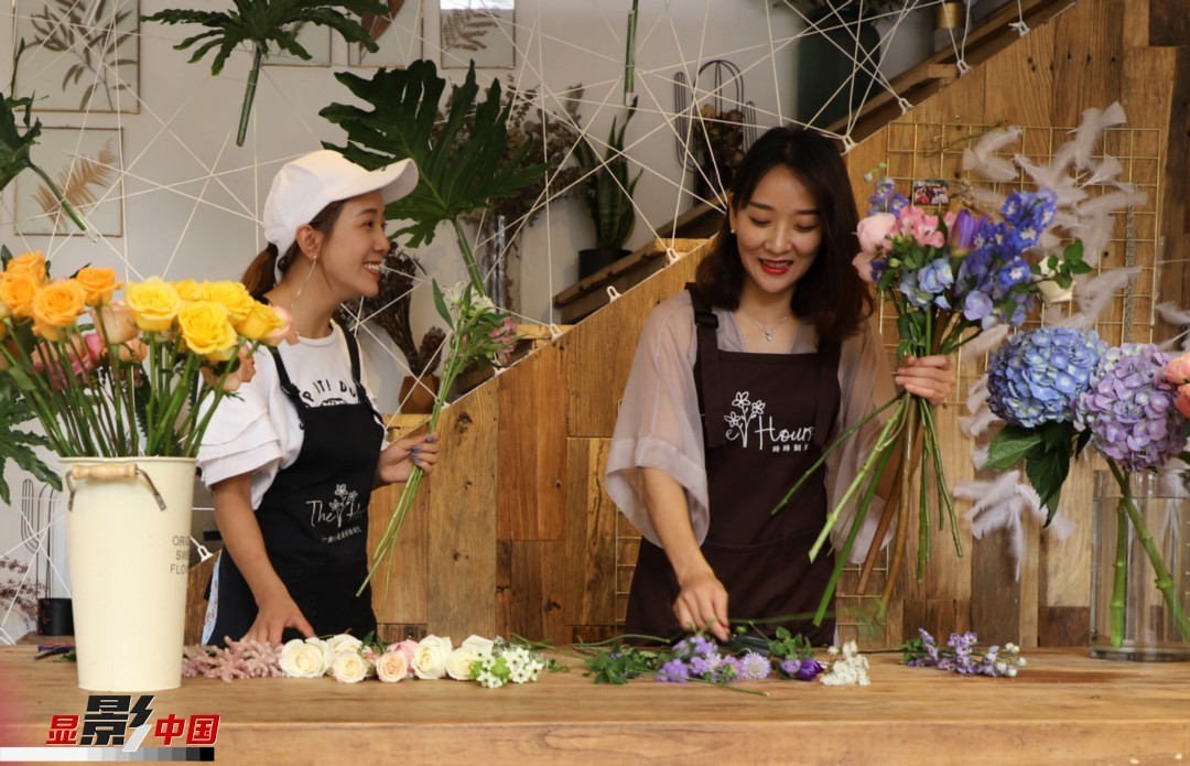 “昆明是鮮花的原產(chǎn)地，有亞洲最大的鮮切花交易市場，可以說具備開花店的天時地利；另外和很多女孩一樣，我從小也就有開花店的夢想！”說起當初的決定，王黎媛說一是因為夢想，另外也跟昆明這個城市產(chǎn)花、賣花的“基因”有關。圖為王黎媛和同事在制作花束。新華網(wǎng) 周亞平/攝 念新洪/文